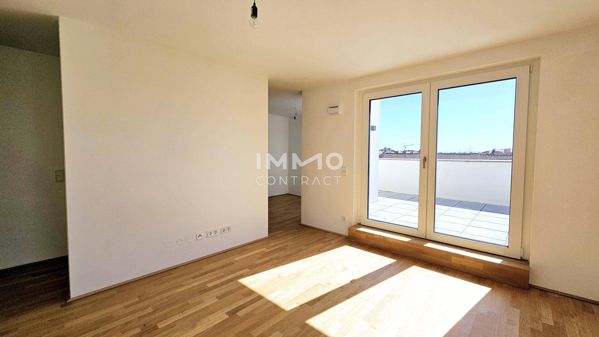 Geräumiger, heller Raum mit Holzboden und direktem Zugang zur sonnigen Terrasse, ideal für Entspannung.