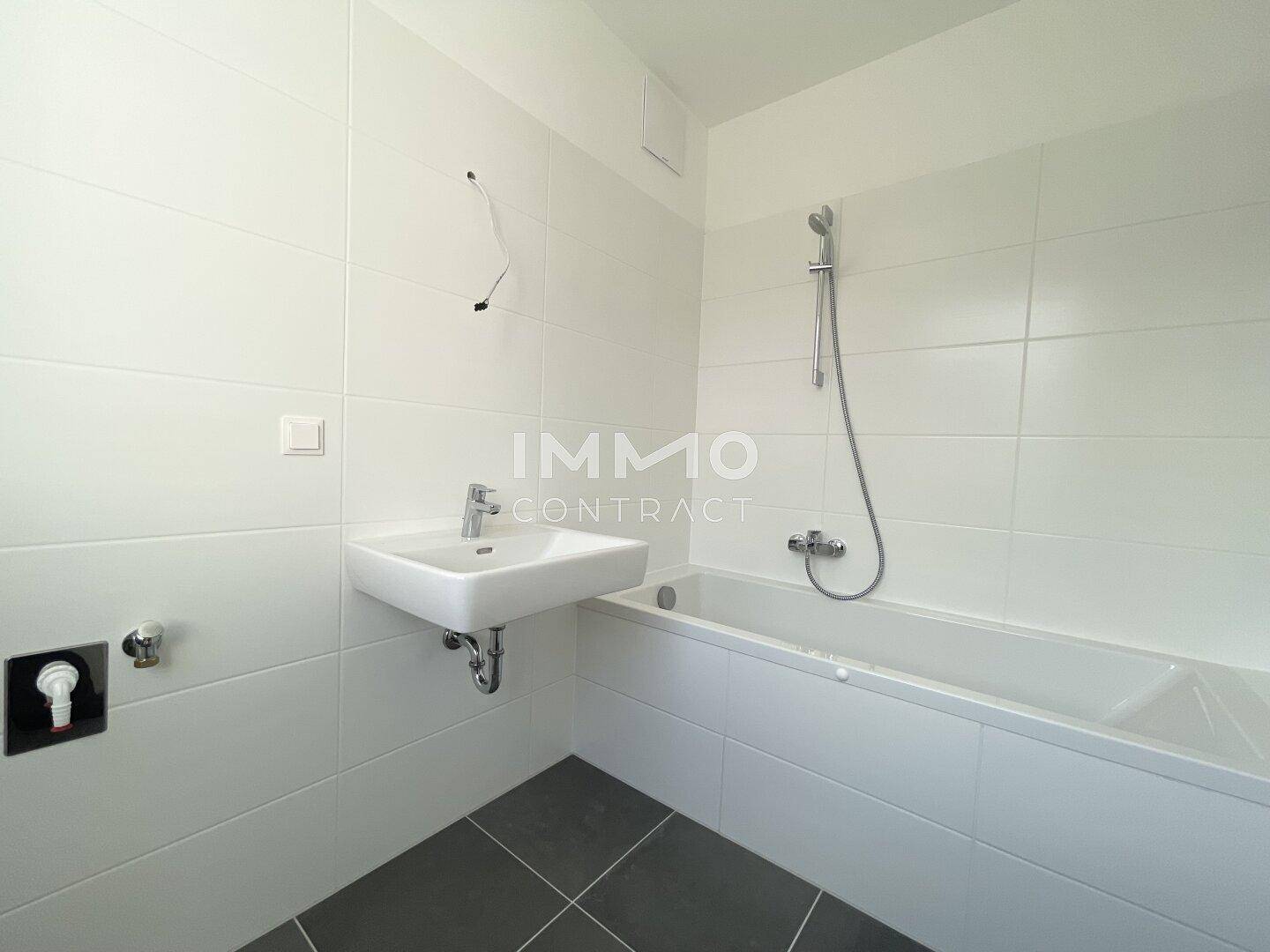 Modernes Badezimmer mit Badewanne, Waschbecken und hellen Fliesen, bereit für die Endmontage.