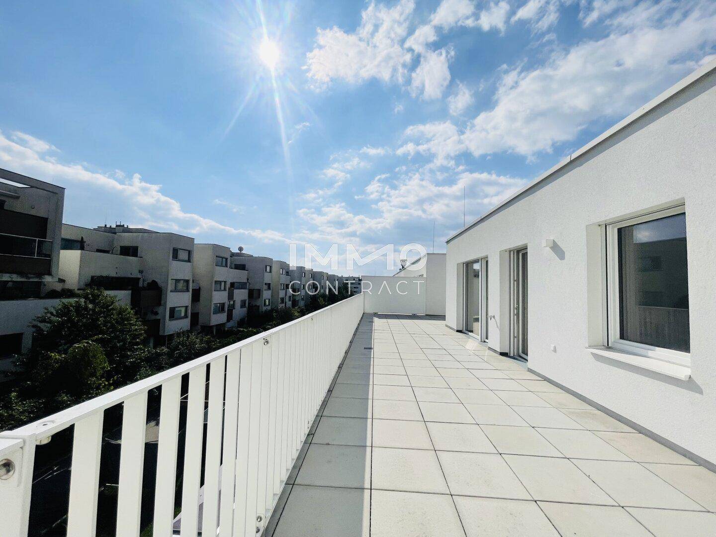 Sonnige Dachterrasse mit moderner Brüstung und weitem Blick über die umliegende Wohnbebauung.
