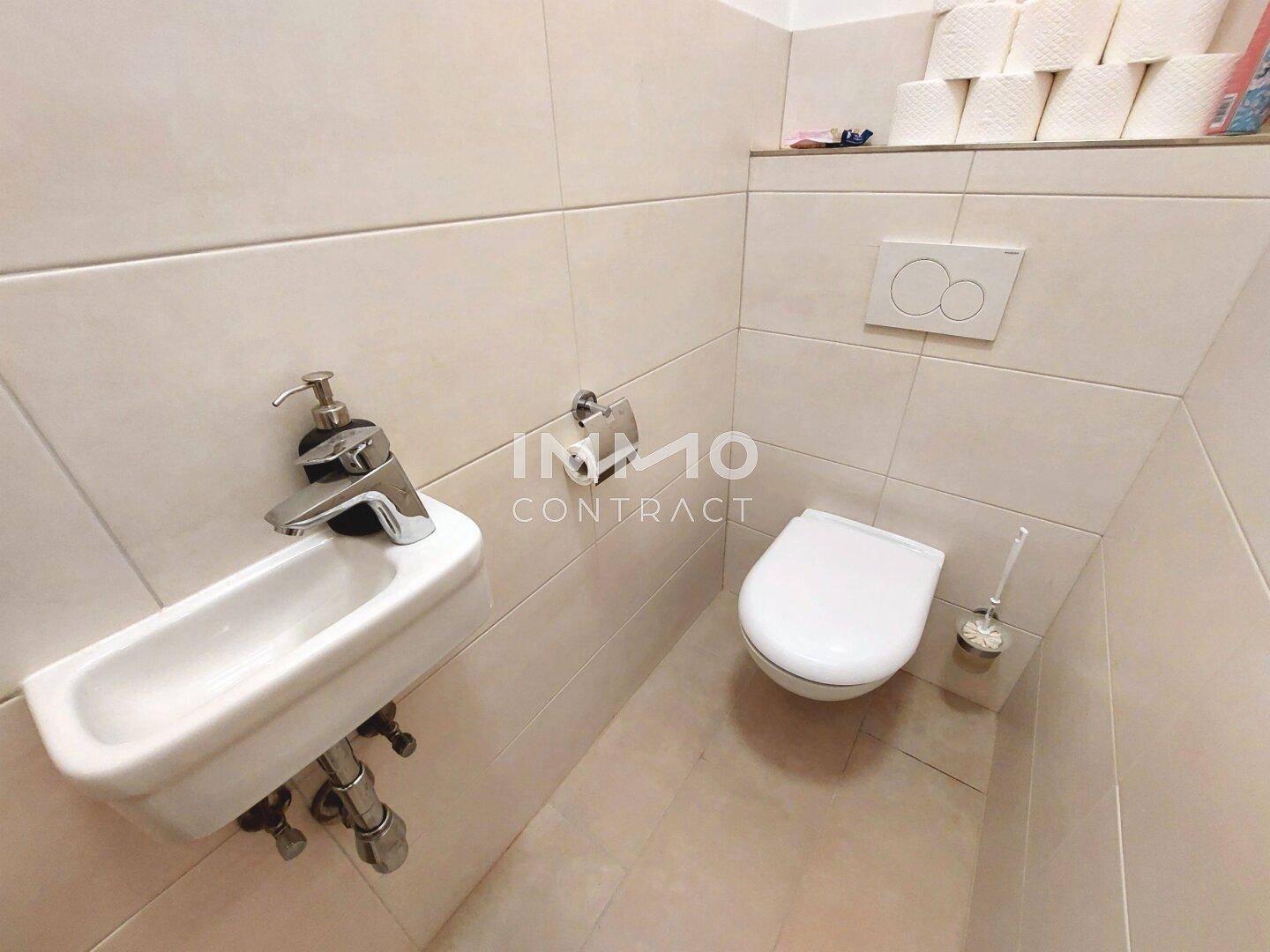 Kleines Gäste-WC mit Wand-WC und Handwaschbecken, komplett gefliest.