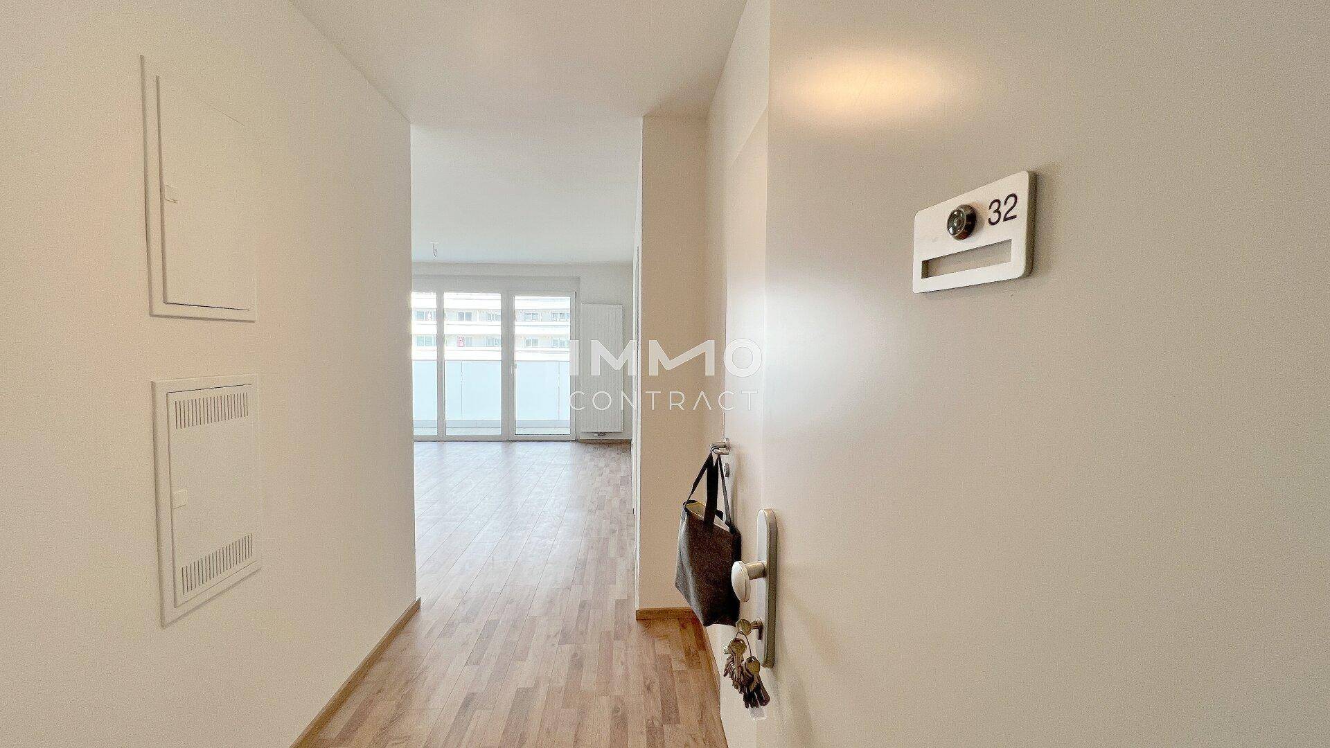 Heller Eingangsbereich mit Laminatboden und Blick in den offenen Wohnbereich der Wohnung.