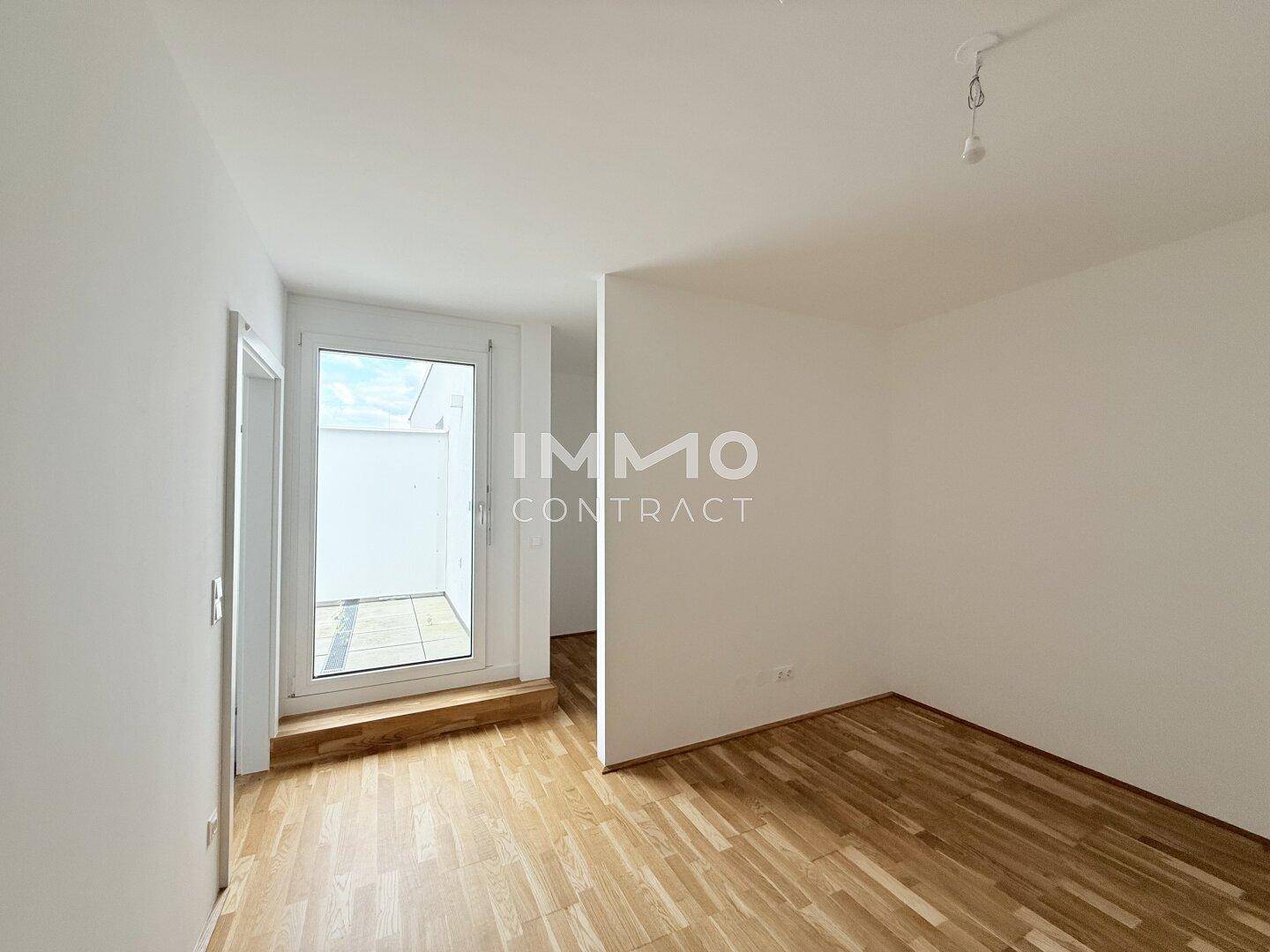 Kleinerer Raum mit Parkettboden und Zugang zu einem Außenbereich, ideal als Schlafzimmer oder Büro.
