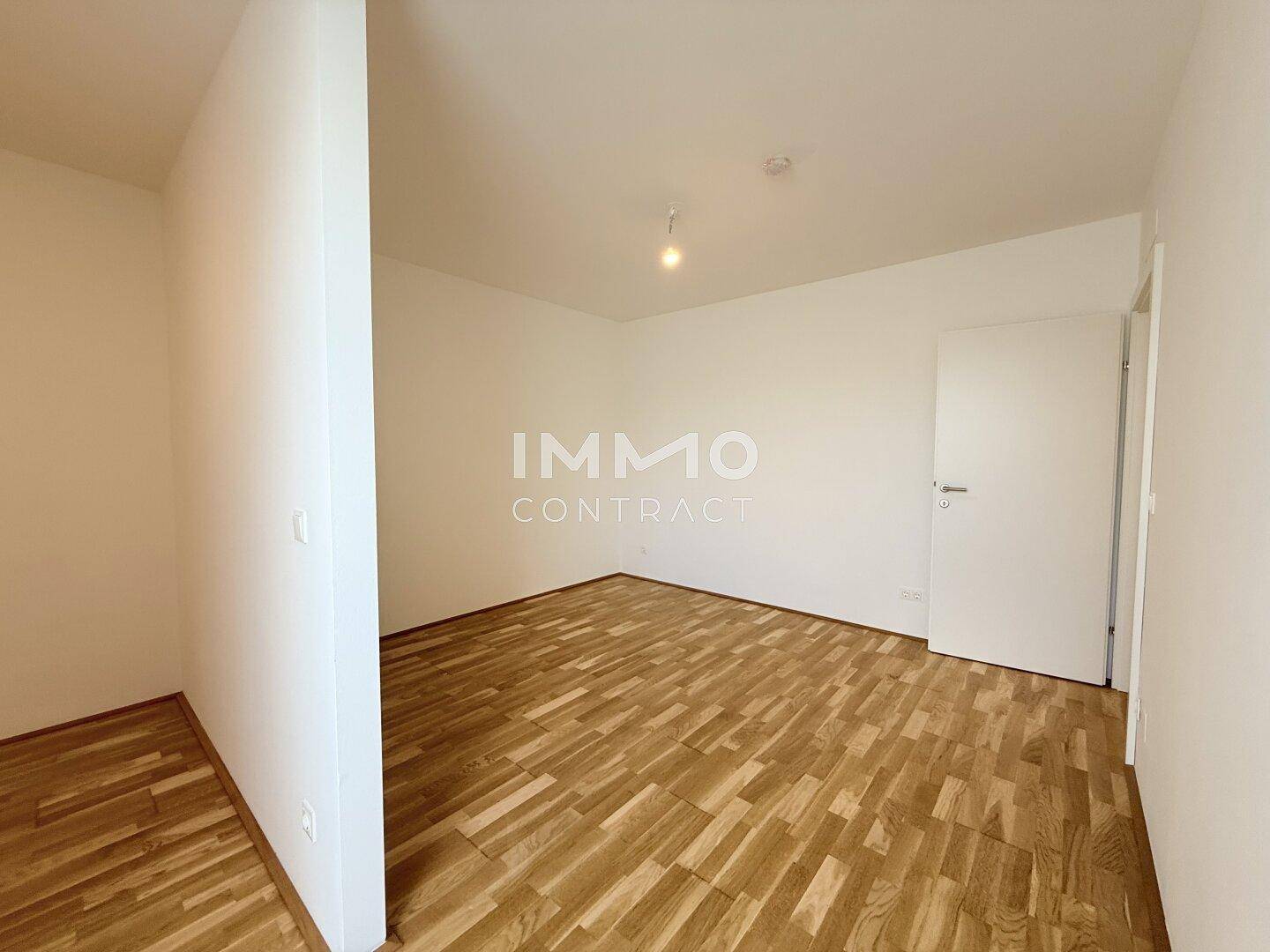 Leeres Schlafzimmer mit Parkettboden und weiß gestrichenen Wänden, bereit zur Einrichtung.