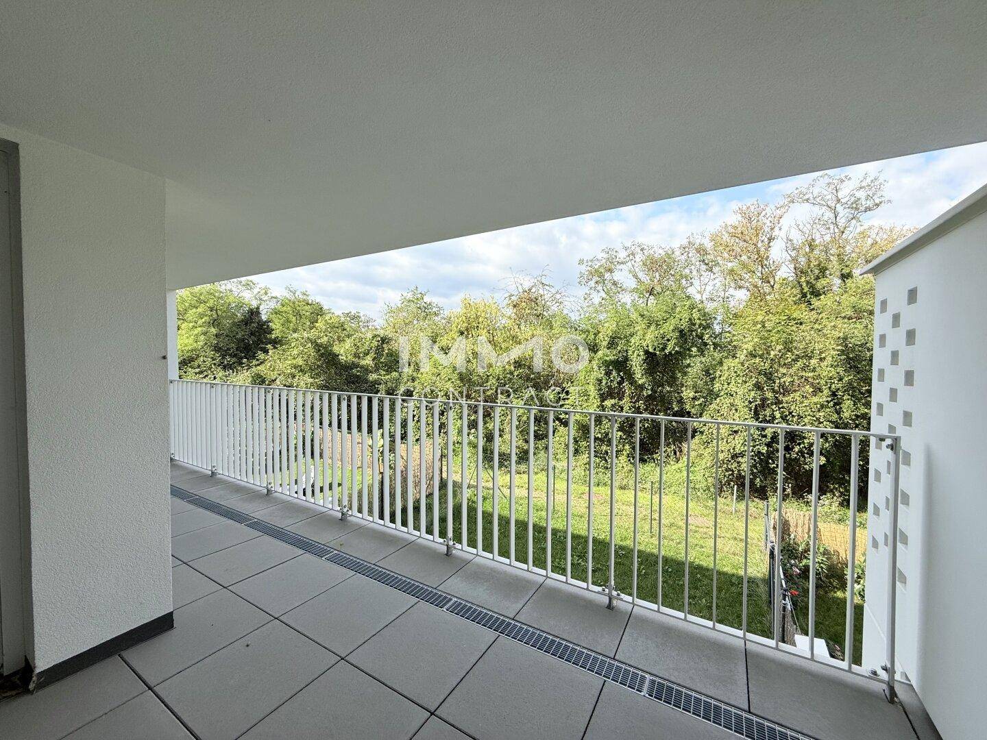 Geräumiger Balkon mit Fliesenboden und Blick ins Grüne, ideal für entspannte Stunden im Freien.