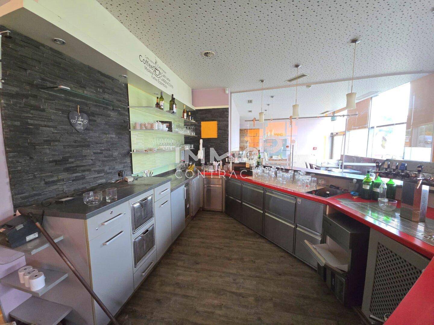 Hinterer Bereich der Bar mit Arbeitsflächen, Schränken und Geräten für die Zubereitung von Getränken.
