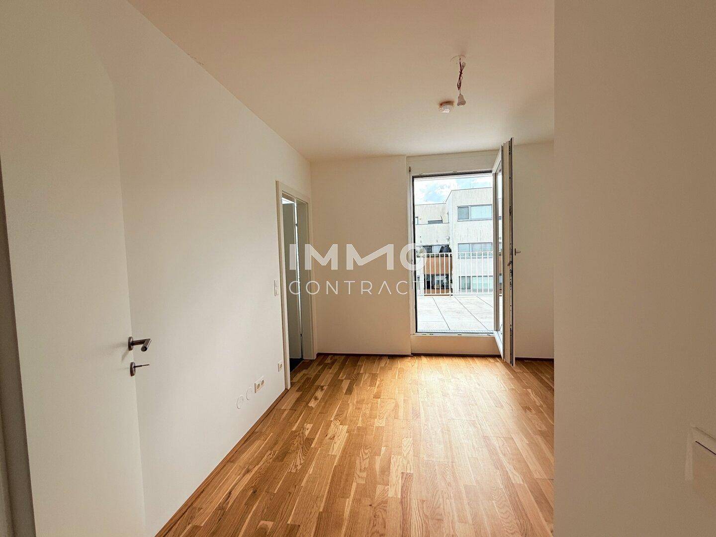 Heller Raum mit Holzboden und direktem Zugang zu einer Terrasse, ideal für ein Schlafzimmer oder Büro.