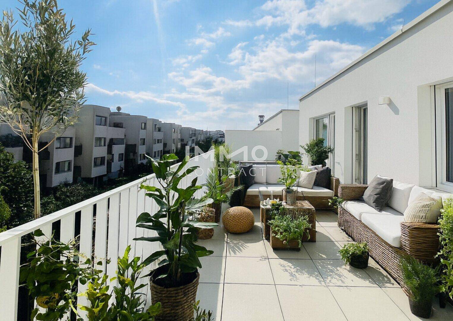 Sonnige Dachterrasse mit stilvollen Outdoor-Möbeln und Pflanzen, perfekt für entspannte Stunden im Freien.