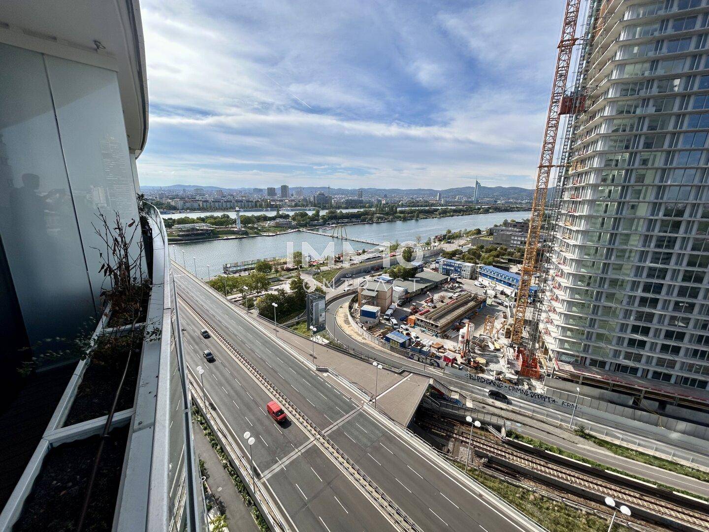 Panoramablick vom Balkon auf die Donau, die Stadt und die umliegende Infrastruktur.
