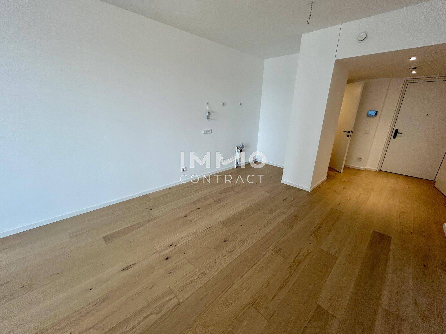 Heller Eingangsbereich mit Holzparkett und integrierten Schränken in modernem Design.