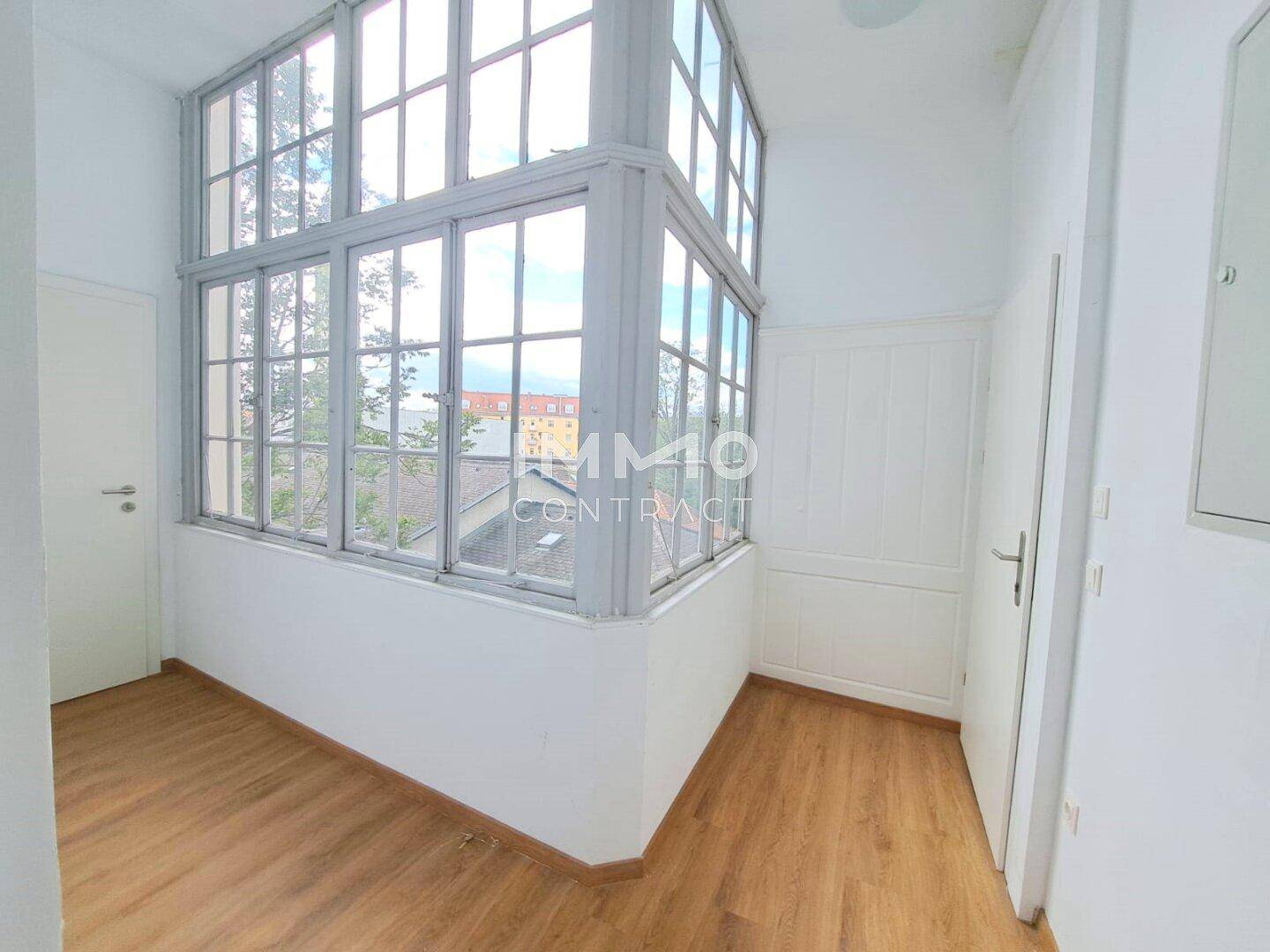 Heller Wintergarten oder verglaster Balkon mit vielen Fenstern und Holzboden, bietet zusätzlichen Wohnraum.