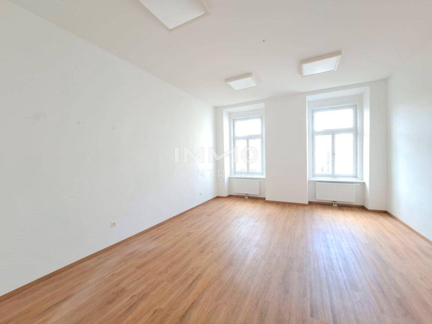 Heller, leerer Raum mit zwei Fenstern und Holzboden, bereit für die individuelle Gestaltung.