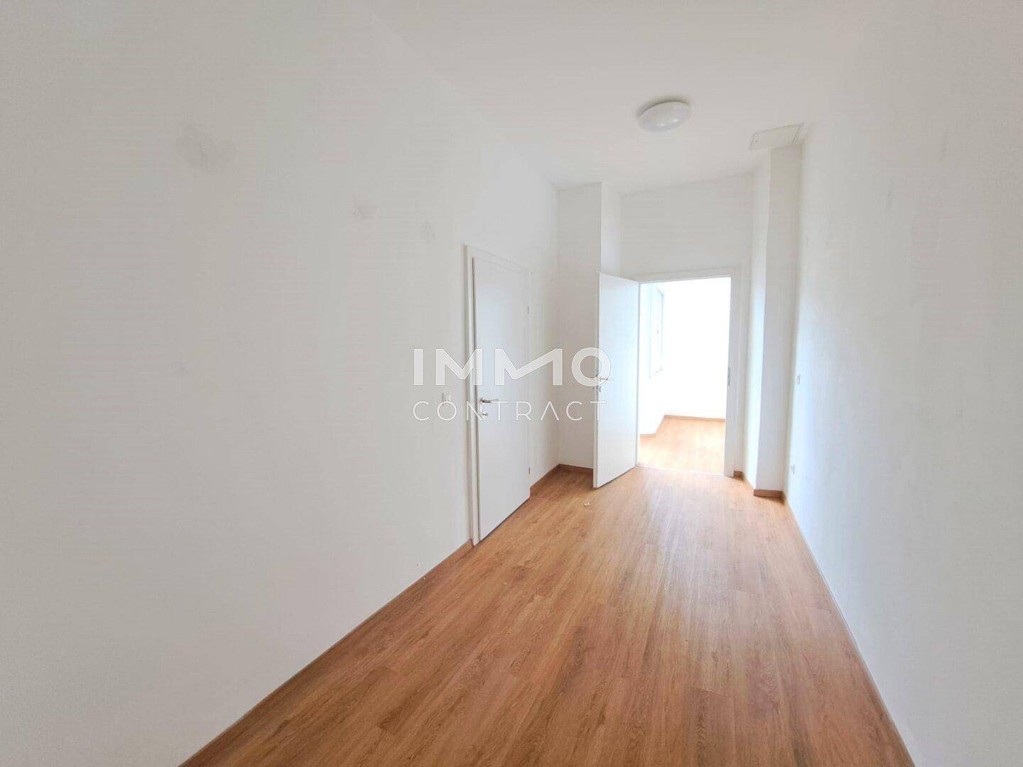 Langer, heller Flur mit Holzboden und Türen, der die verschiedenen Bereiche der Wohnung verbindet.