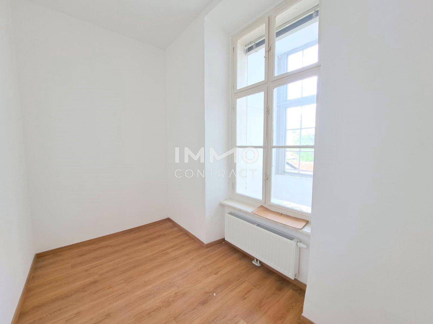 Kleiner, heller Raum mit einem Fenster und Holzboden, ideal als Schlafzimmer oder Arbeitszimmer.