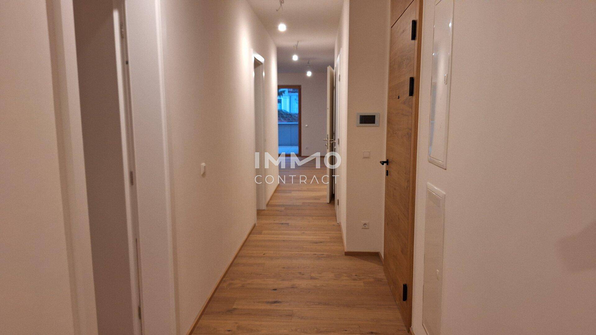 Heller Flur mit Holzboden und modernen Türen, der zu den verschiedenen Räumen führt.