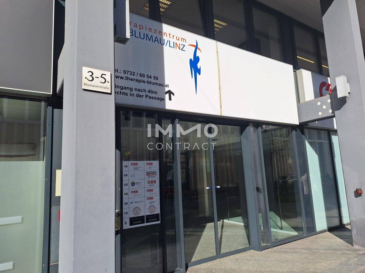 Eingangsbereich eines Therapiezentrums mit großen Glasfenstern und Beschilderung an der Fassade.
