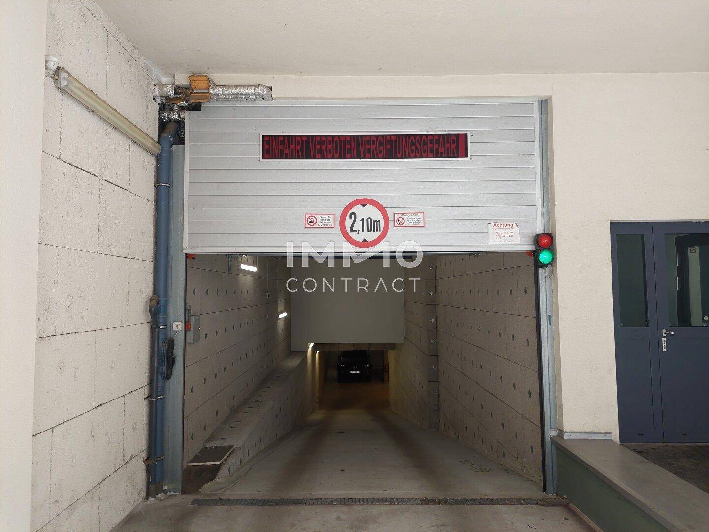 Einfahrt zur Tiefgarage mit Höhenbegrenzung und Warnhinweisen.