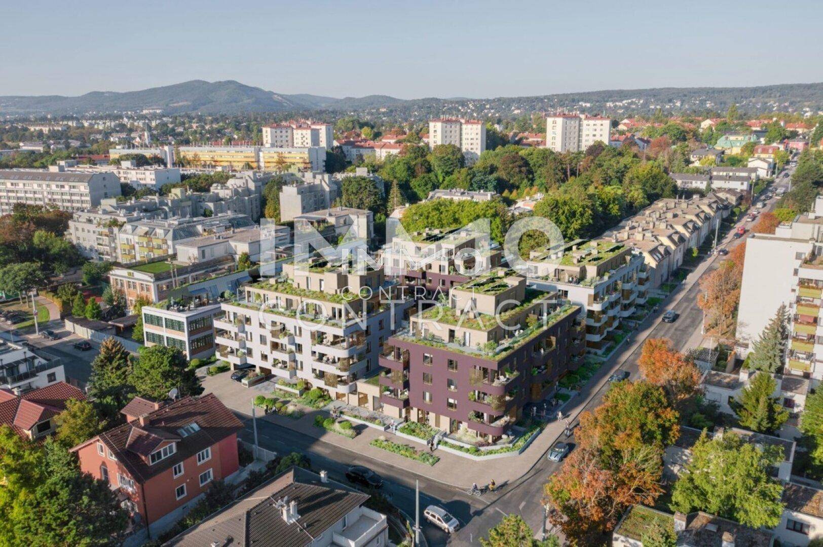 Luftaufnahme einer modernen Wohnanlage in städtischer Umgebung mit begrünten Dächern und Balkonen.