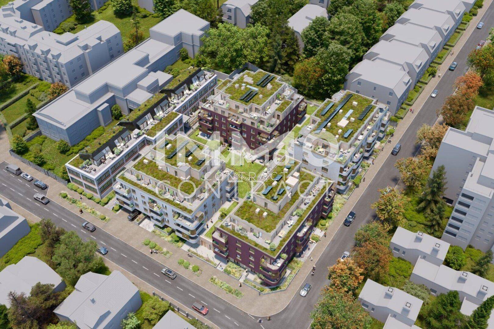 Vogelperspektive einer modernen Wohnsiedlung mit vielen begrünten Dächern und Balkonen in urbaner Lage.