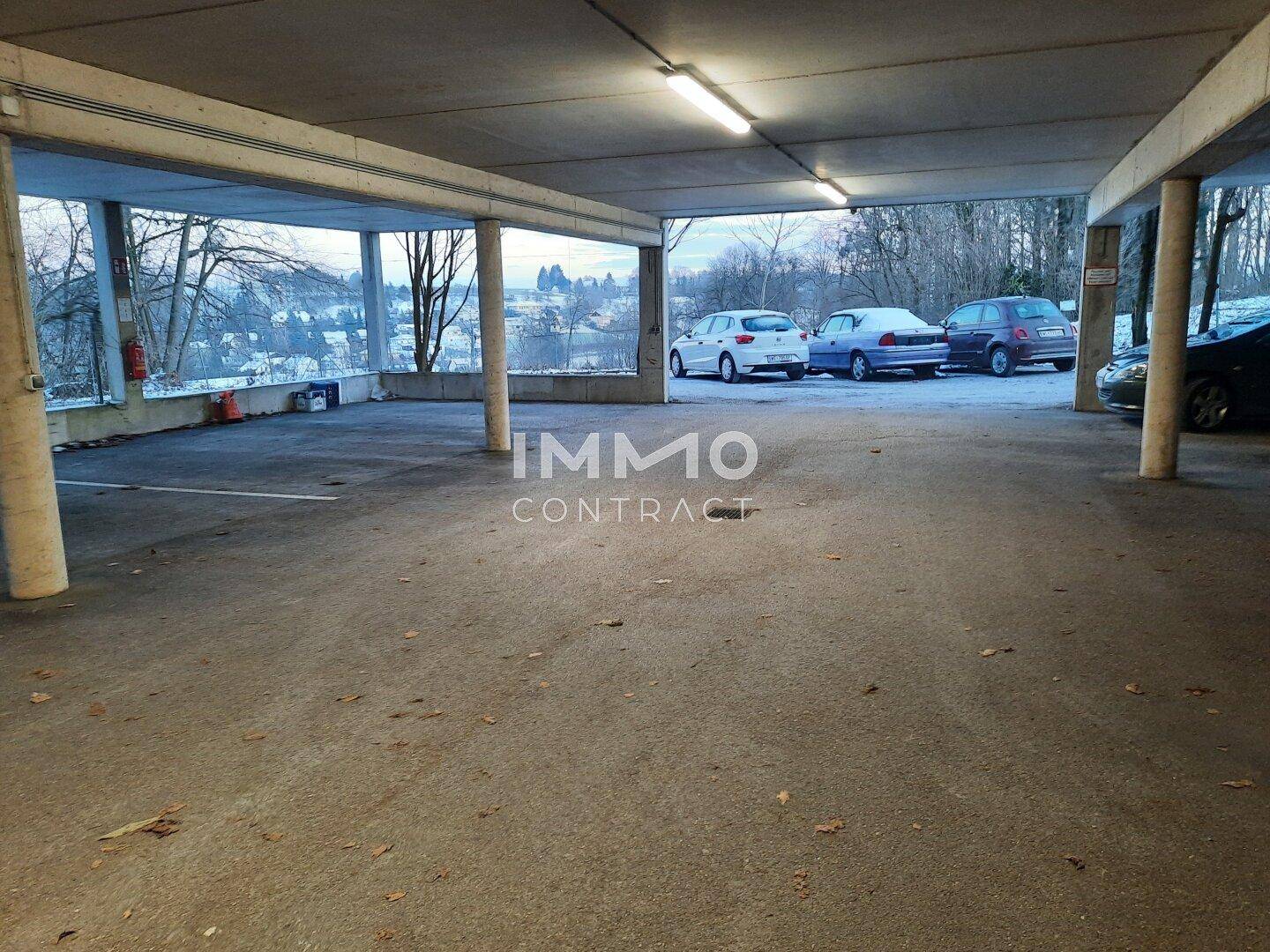 Geräumige Tiefgarage mit Betonkonstruktion und mehreren Stellplätzen für Bewohner.