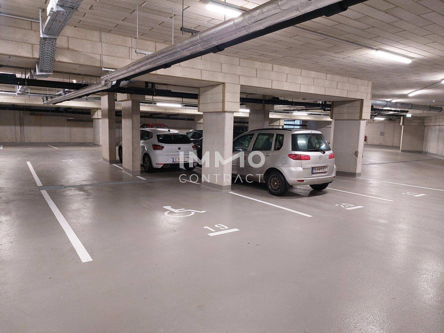 Tiefgarage mit markierten Stellplätzen und barrierefreien Parkmöglichkeiten.
