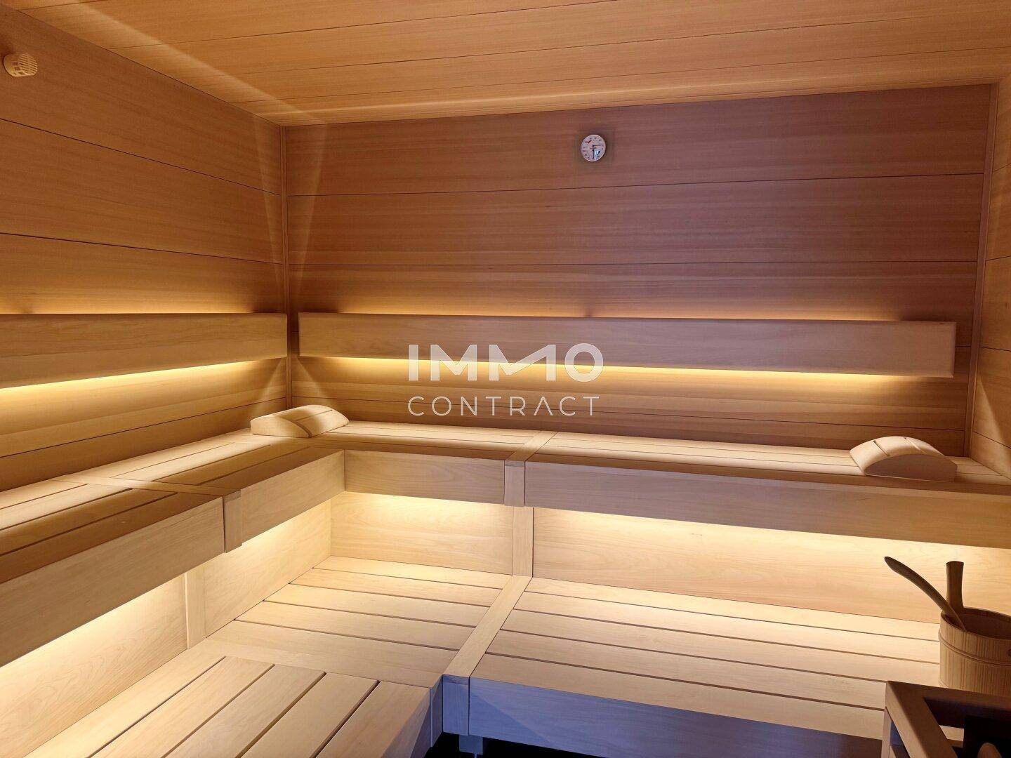 Gemütliche Holzsauna mit mehreren Bänken und indirekter Beleuchtung für entspannende Momente.
