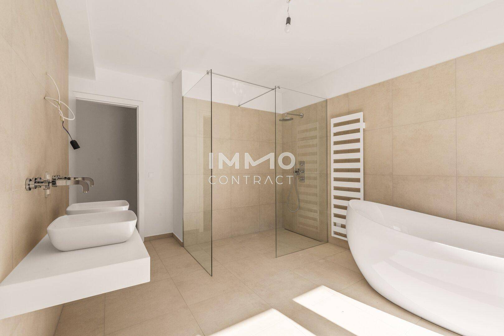 Geräumiges, modernes Badezimmer mit begehbarer Dusche, freistehender Badewanne und Doppelwaschbecken.