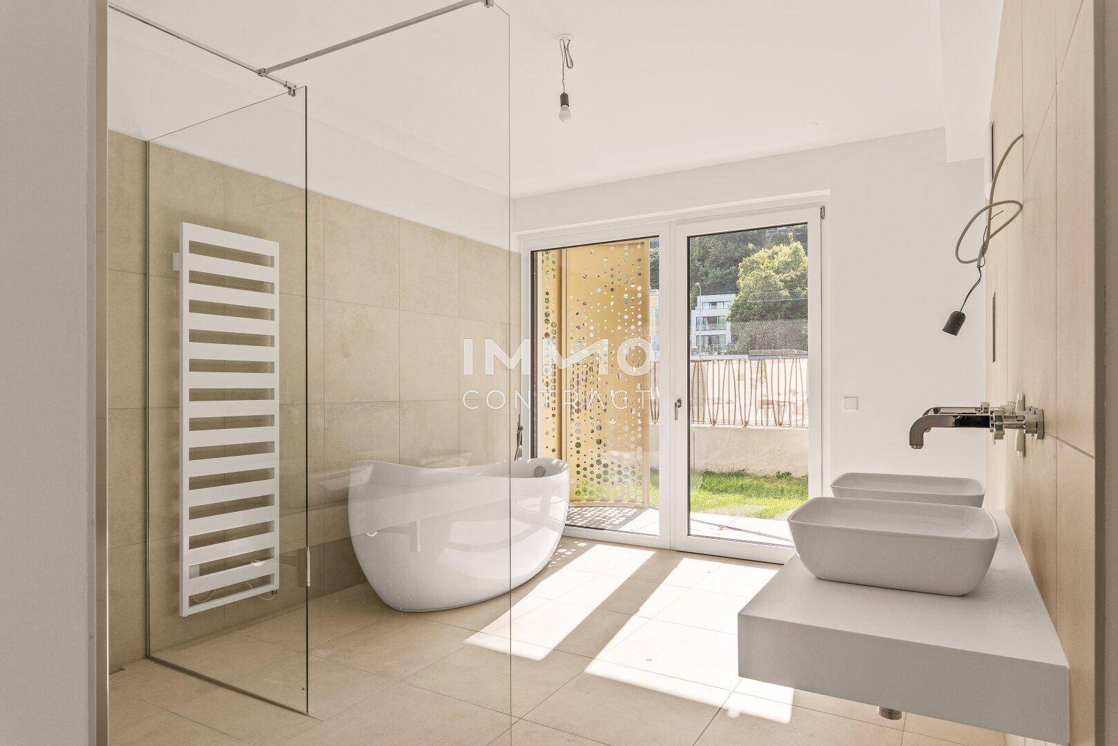 Modernes Badezimmer mit freistehender Badewanne, Doppelwaschbecken und begehbarer Dusche.