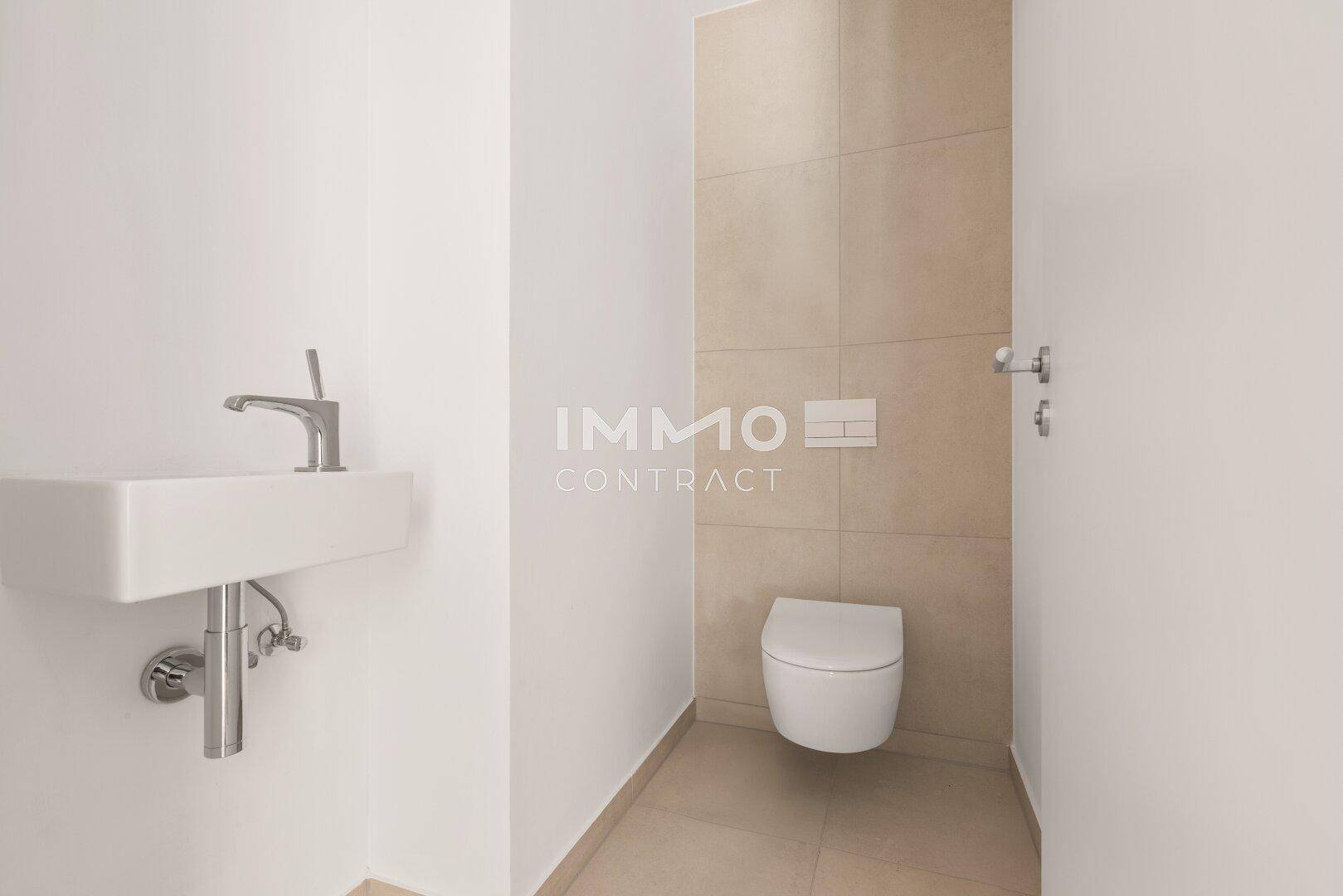 Modernes Gäste-WC mit wandhängender Toilette und kleinem Waschbecken in neutralen Farben.