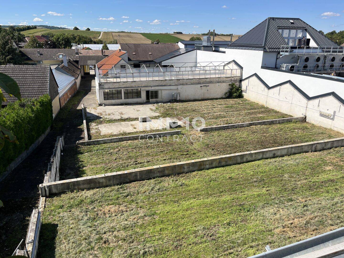 Weitläufiges Grundstück mit Grasflächen und Blick auf benachbarte Häuser und die ländliche Umgebung.