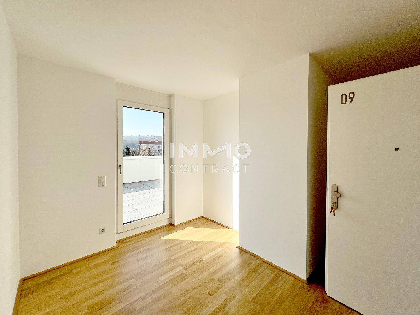 Helles Zimmer mit Parkettboden und direktem Zugang zu einer sonnigen Terrasse.