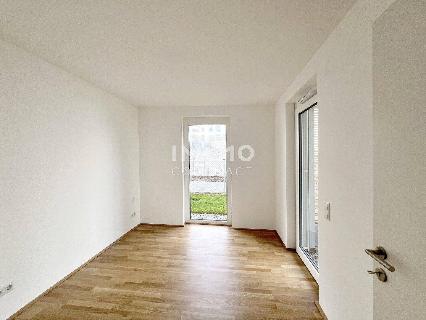 Helles Zimmer mit Holzboden und direktem Zugang zum Außenbereich.