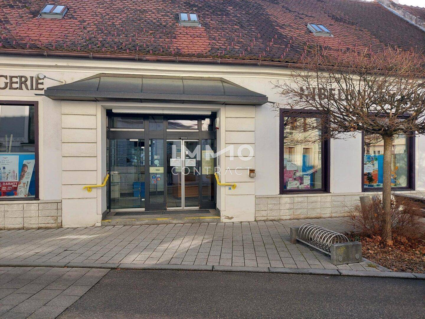 Nahaufnahme des Eingangs einer Drogerie mit Rampe und Haltegriffen für Barrierefreiheit.