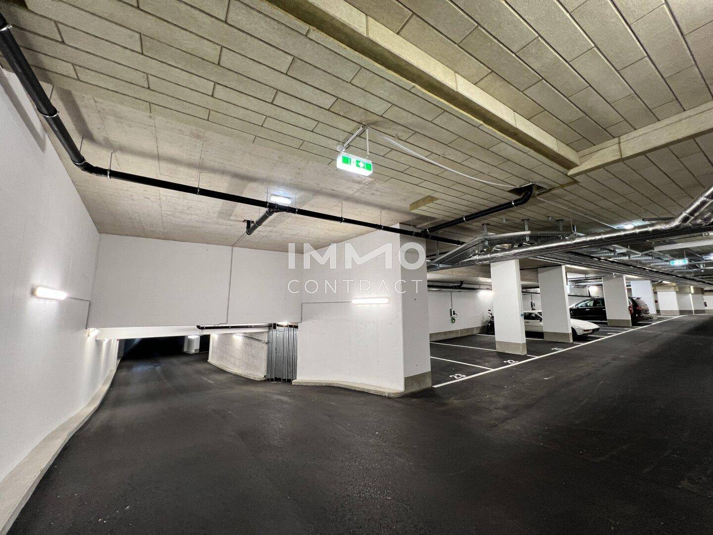 Geräumige Tiefgarage mit markierten Stellplätzen und moderner Beleuchtung.