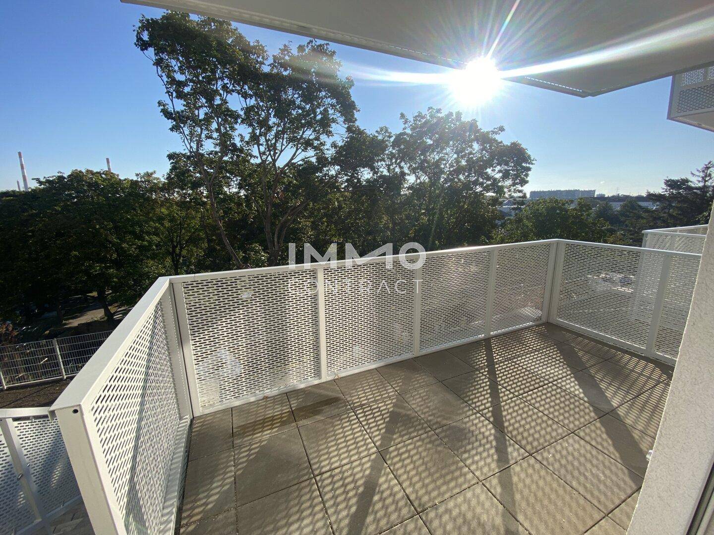 Sonniger Balkon mit moderner Lochblechbrüstung und weitem Blick.