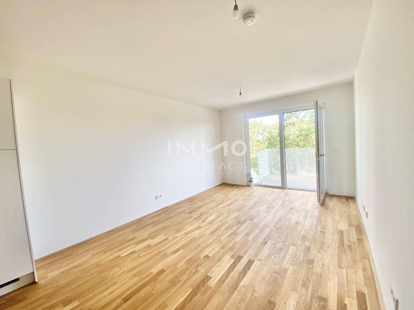Helles Zimmer mit Holzboden und Zugang zu einem Balkon, vielseitig nutzbar.