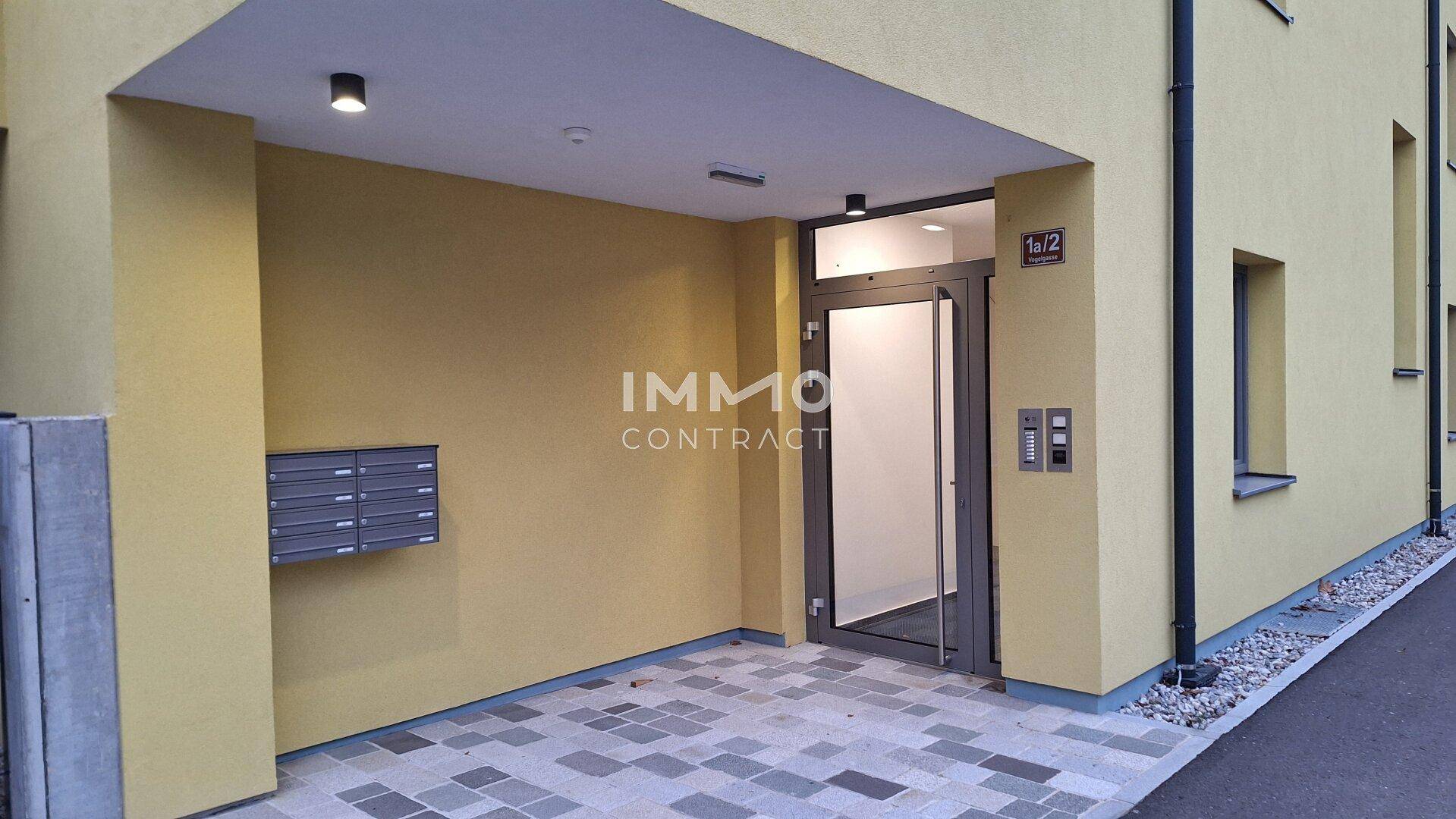 Moderner Gebäudeeingang mit Briefkästen und Zugang zum Treppenhaus.
