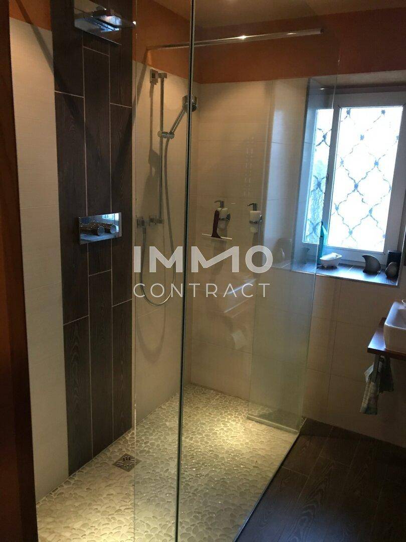Modernes Badezimmer mit ebenerdiger Dusche, Fliesen und Fenster für Tageslicht.