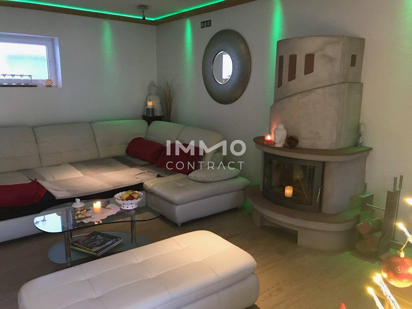 Modernes Wohnzimmer mit Ecksofa, Kamin und indirekter Beleuchtung für gemütliche Abende.