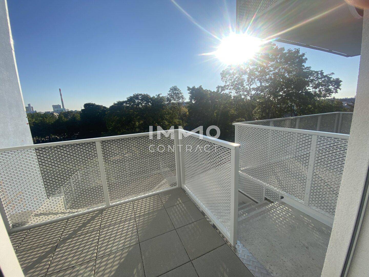 Heller Balkon mit moderner Metallbrüstung und sonnigem Ausblick.