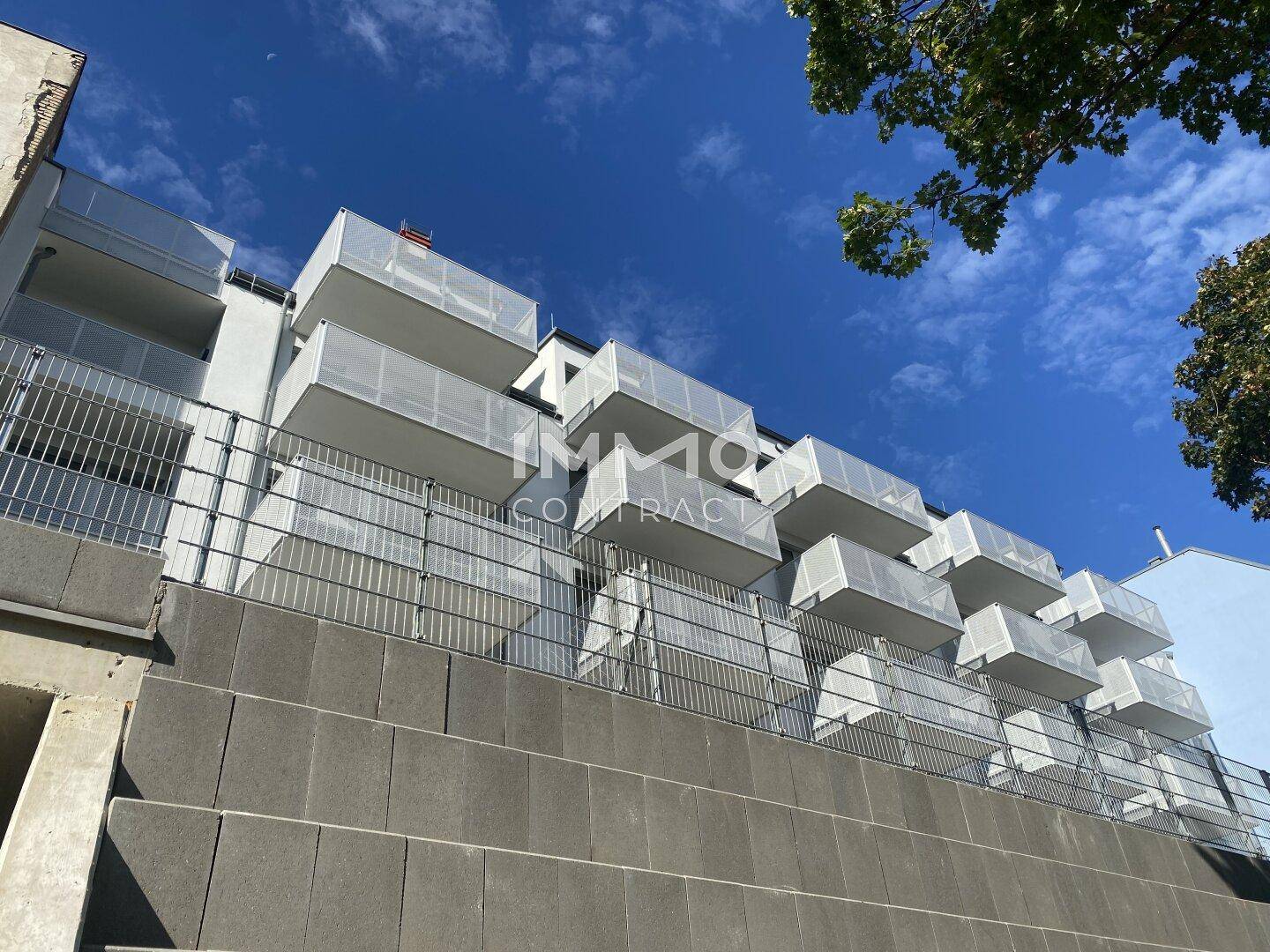 Moderne Wohnanlage mit gestuften Balkonen und einer robusten Fassade.