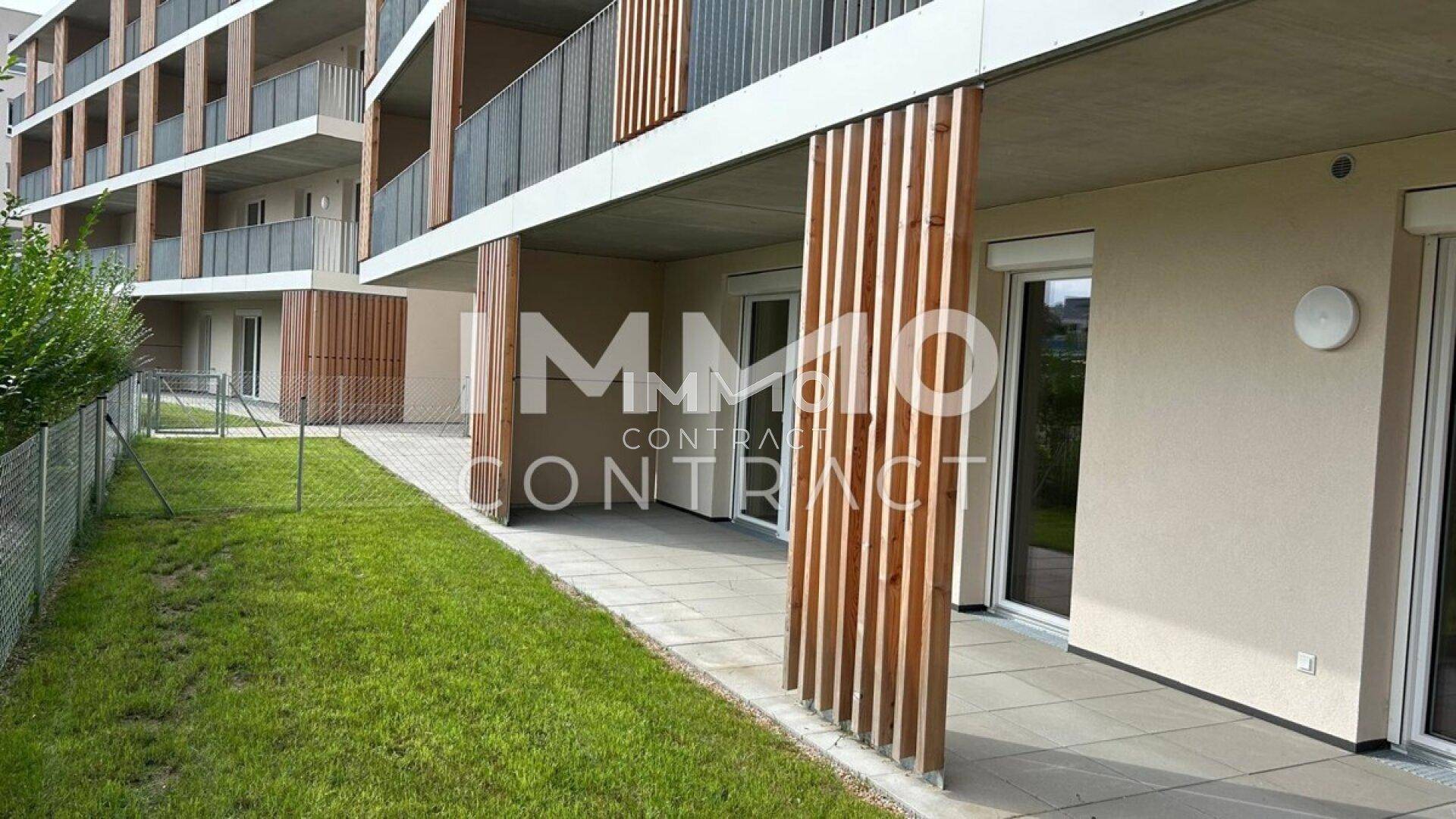 Ebenerdige Terrasse mit Zugang zum Garten und vertikalen Holzlamellen an der Fassade.