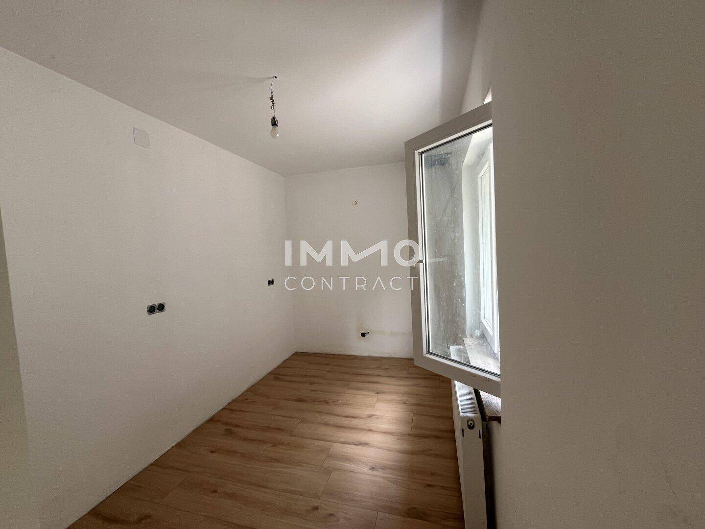 Kleinerer Raum mit Laminatboden und einem geöffneten Fenster, ideal als Kinder- oder Arbeitszimmer.