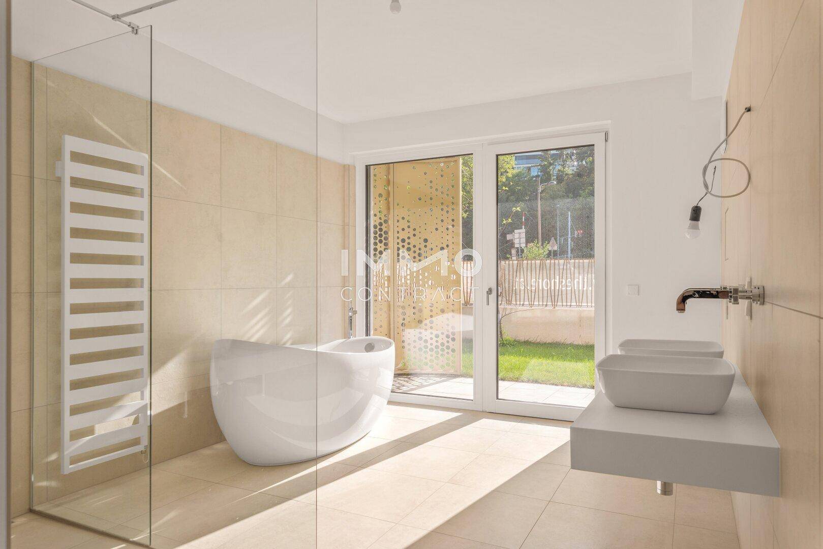 Modernes Badezimmer mit freistehender Badewanne, ebenerdiger Dusche und Doppelwaschbecken.