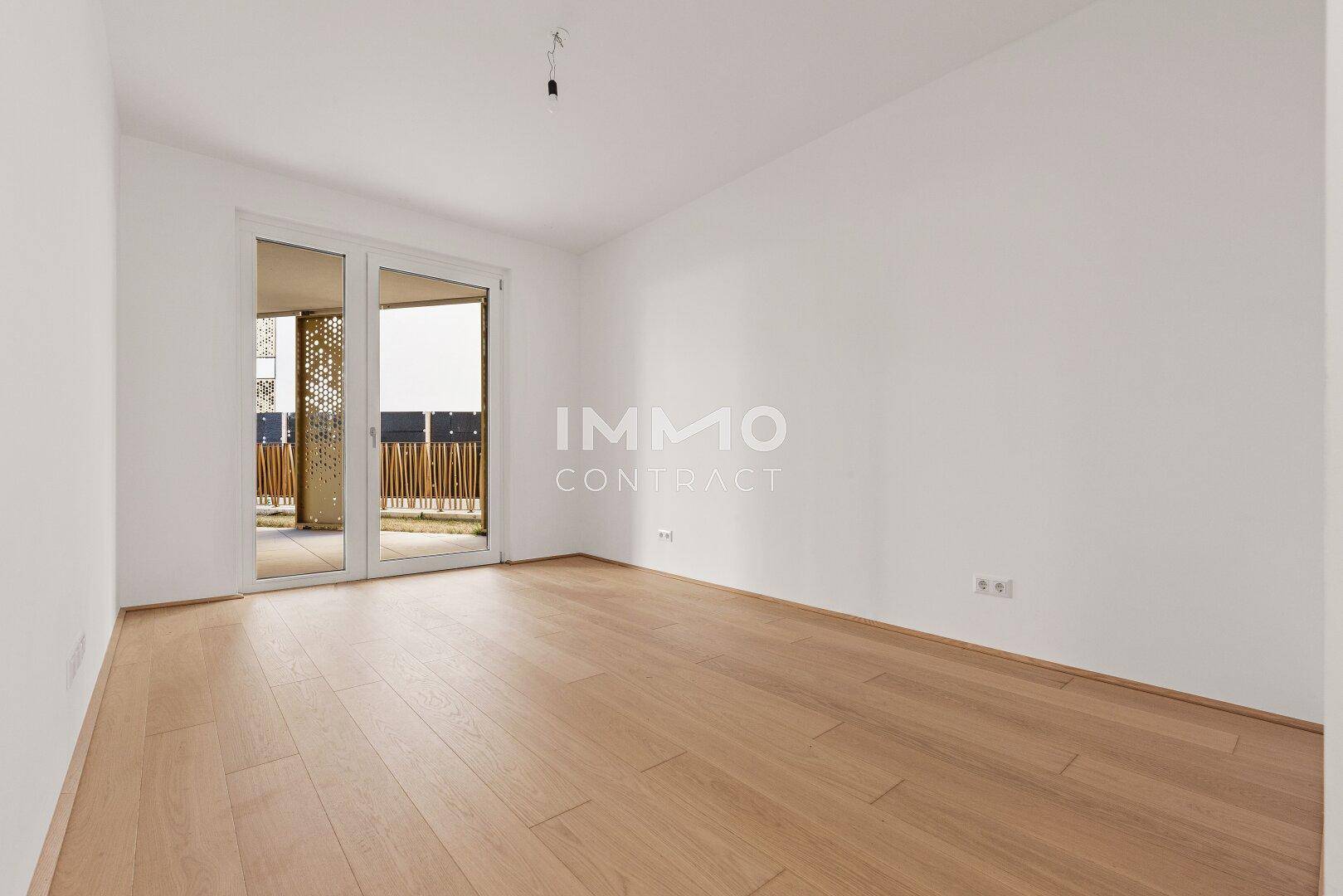 Modernes Schlafzimmer mit Holzboden und Schiebetür zu einem Außenbereich mit dekorativen Elementen.