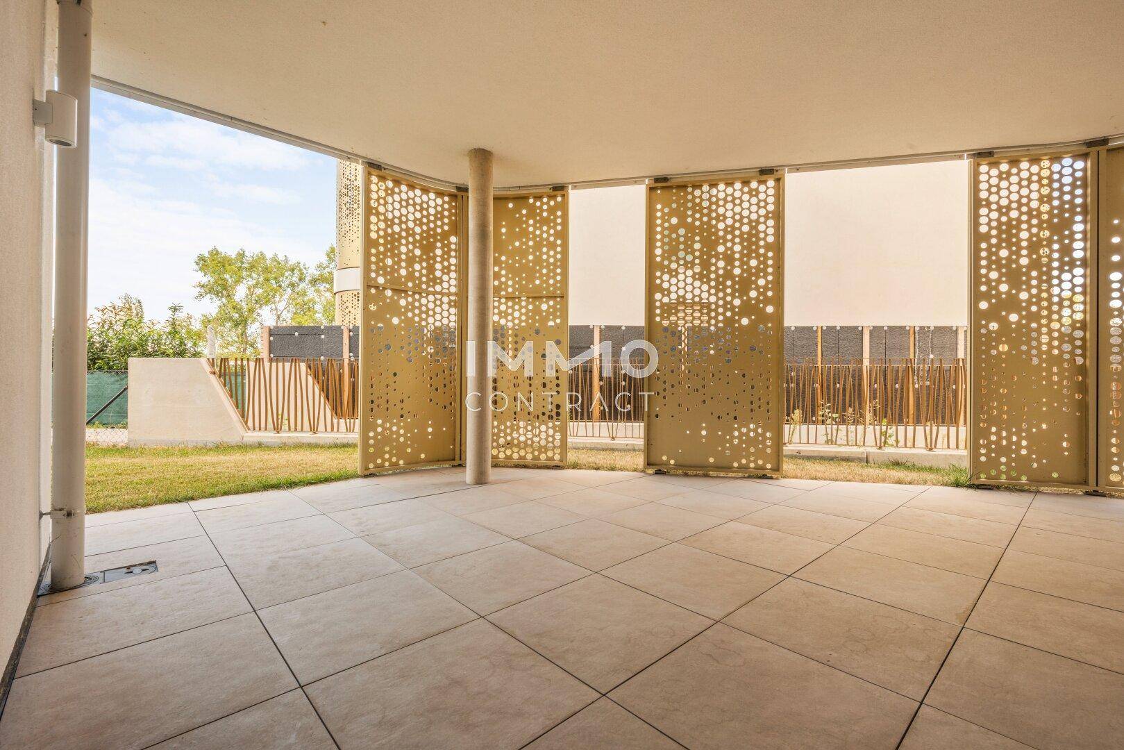 Überdachte Terrasse mit Fliesenboden und dekorativen Sichtschutzelementen, ideal für Entspannung.
