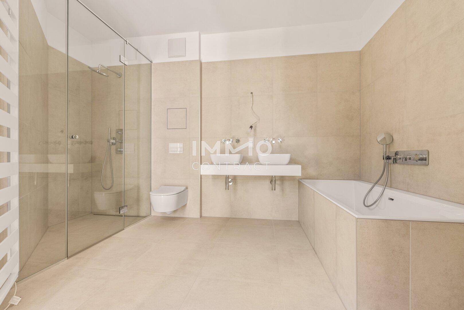 Luxuriöses Badezimmer mit Doppelwaschbecken, großer Dusche, Badewanne und modernen Fliesen.