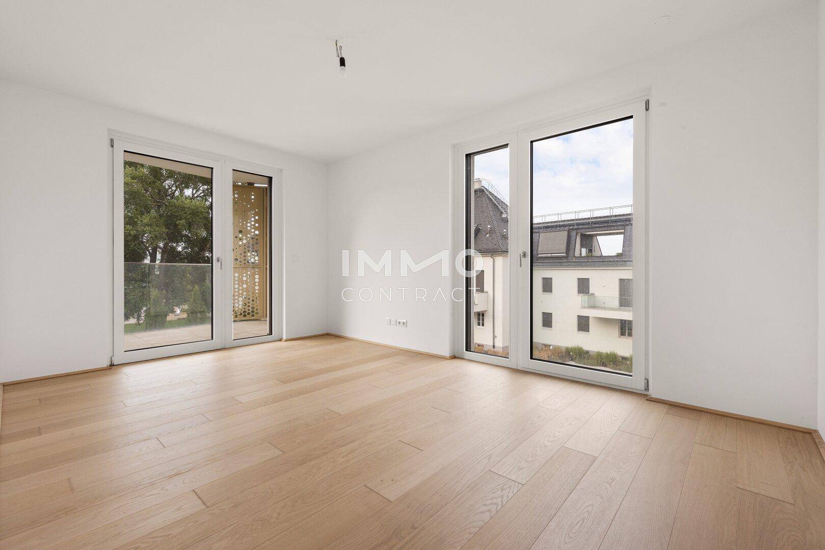 Helles Zimmer mit Holzboden und Zugang zu einem Balkon, bietet vielseitige Nutzungsmöglichkeiten.