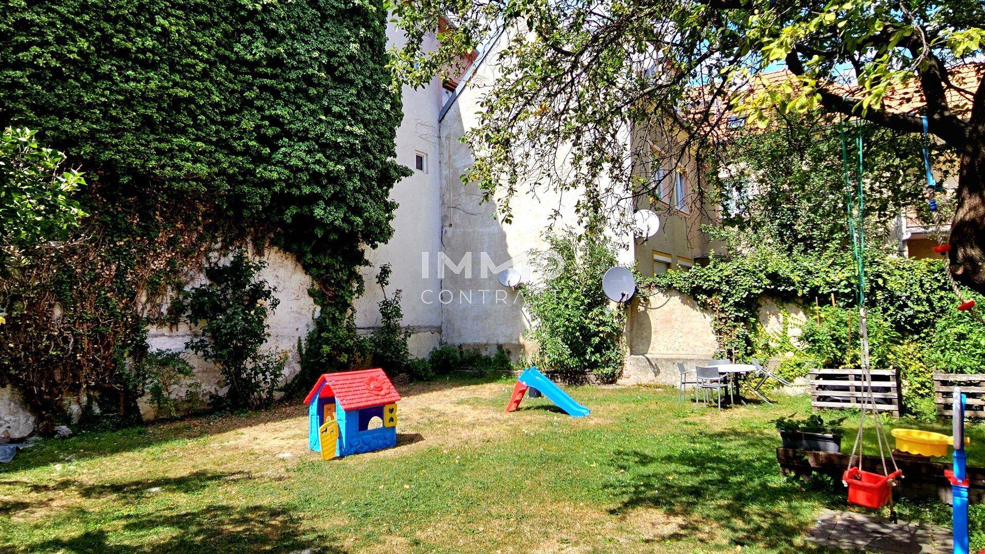 Großer, sonniger Garten mit Spielgeräten, Bäumen und viel Platz zum Entspannen.