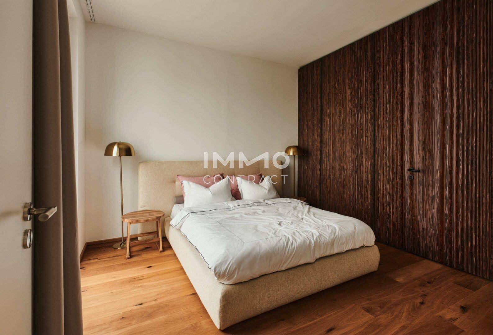 Modernes Schlafzimmer mit Holzwandverkleidung, Parkettboden und indirekter Beleuchtung.