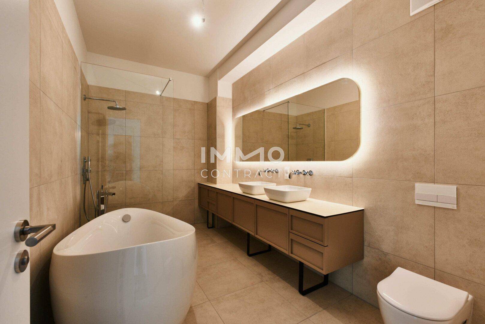 Luxuriöses Badezimmer mit freistehender Badewanne, Doppelwaschbecken und Regendusche.